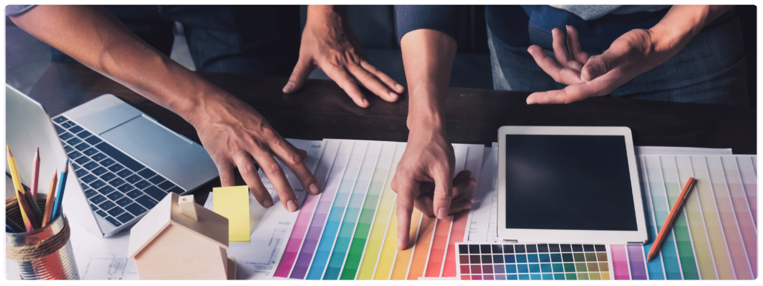 Pessoas de uma agência de publicidade escolhendo uma paleta de cores para representar o tema do post, destacando a importância da escolha de cores no design visual para uma estratégia de marketing digital eficaz.